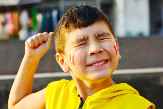 Excited little peruvian with national flag painted on cheeks.