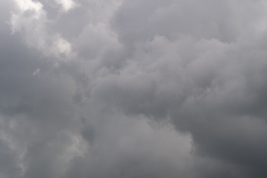 Thick thunderheads gather with heavy mood, deep grays and concealed light imply imminent storm and intensity strong visual for climate stories and dramatic editorials