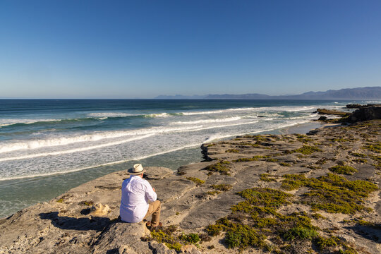 adult man wearing hat exploring beautiful Walker Bay Nature Reserve, Gansbaai, South Africa