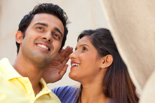 Woman whispering in a mans ear