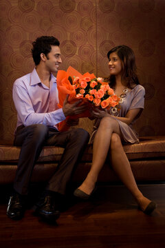 Man giving bouquet of flowers to a woman