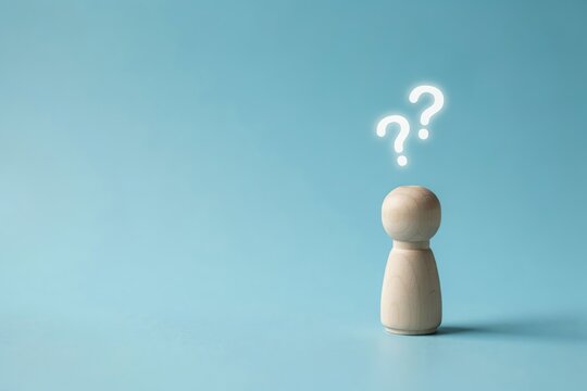 Wooden peg doll with question marks above head representing confusion or uncertainty thought bubble