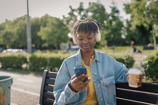 Young black woman relaxing on park bench