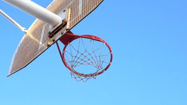 Basketball player making a slam dunk outdoors