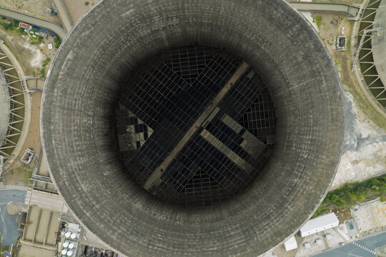 Aerial view of a large industrial cooling tower, showing the circular concrete structure and internal grid-like cooling system from directly above in the United Kingdom.