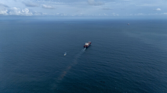 Aerial view of a large cargo ship navigating the deep blue waters of the Atlantic Ocean near the coast of Lagos, Lagos, Nigeria.