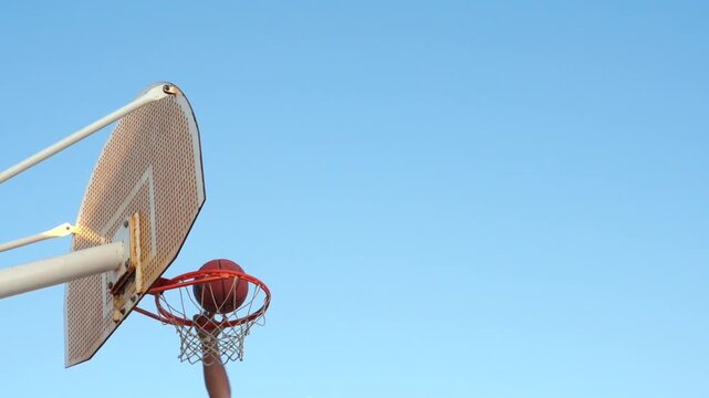 Basketball player scoring a basket outdoors