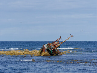 The disintegrating wreck of the Sovereign Fishing Boat on the rocks at Cairnbulg Point in Fraserburgh Bay at Low Tide. © Julian