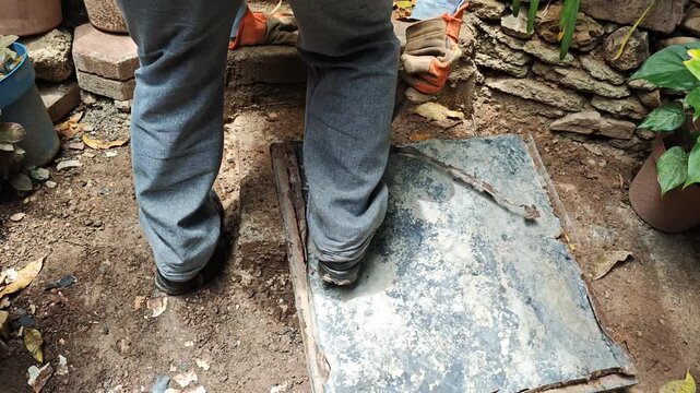 Young Man Using Pry Bar Tool to Remove Old Metal Sheet