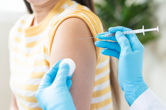 Close up of doctor in blue gloves giving vaccination injection to patient.