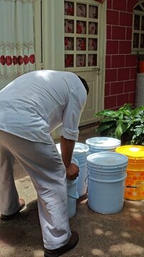 Young Man Sealing Lid of Water Container Outdoors