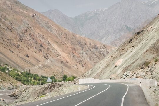 An asphalt road on the Pamir Highway in the Panj River Valley along the border of Afghanistan and Tajikistan, a road among rocky mountains