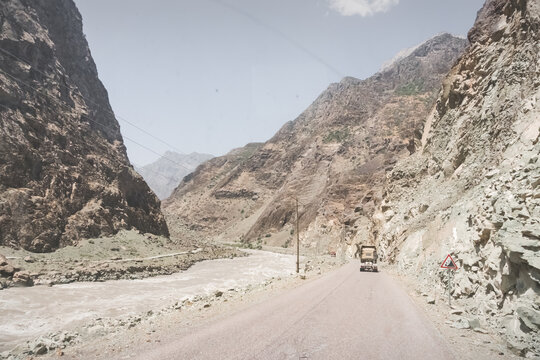 An asphalt road on the Pamir Highway in the Panj River Valley along the border of Afghanistan and Tajikistan, a road among rocky mountains