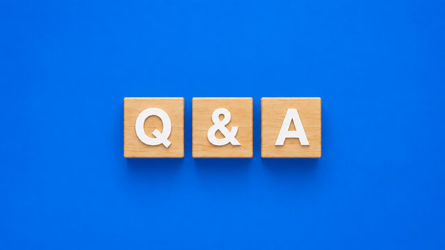 Q and a wooden blocks aligned in center on vibrant blue background.