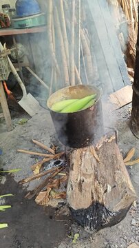 Dense Smoke Rising from Campfire Cooking Corn in Metal Pot