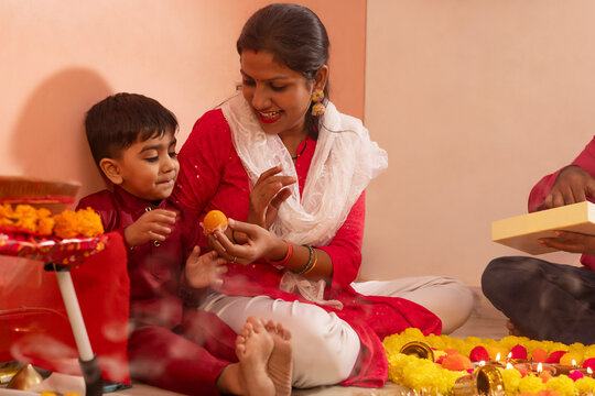 Mother and son sharing sweets during Diwali