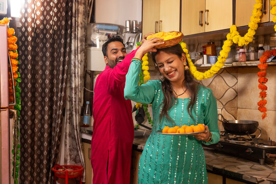 Couple playfully interacting in a decorated kitchen during a festival