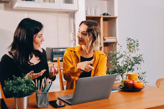 Portrait of military mother helping teen daughter with homework and eating lunch