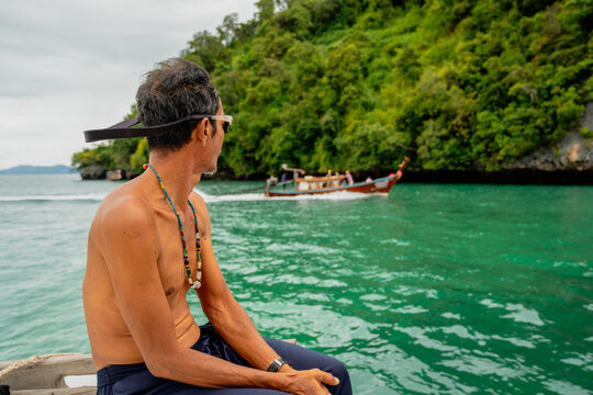 Boatman enjoying scenic longtail boat cruise in andaman sea