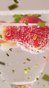 Animation of confetti falling and cocktail on white background