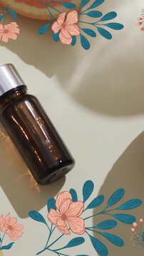 Animation of frame of flowers with brown bottle, oranges and copy space over white background