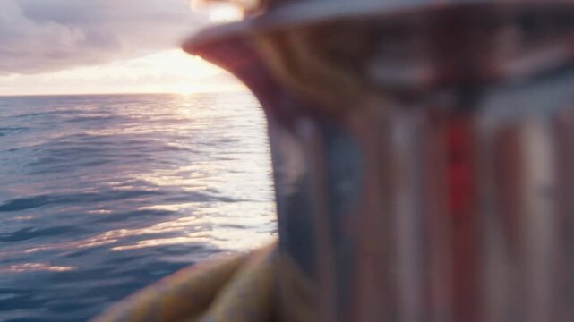 Sailing boat moves in the Atlantic Ocean, details of the vessel. Sunset as seen from the moving sailing boat with winch on the foreground