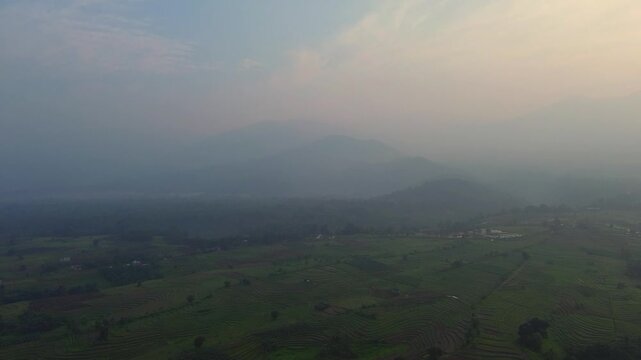 the beauty of the foggy morning panorama with sunrise and rice fields in Bengkulu, indonesia, asia