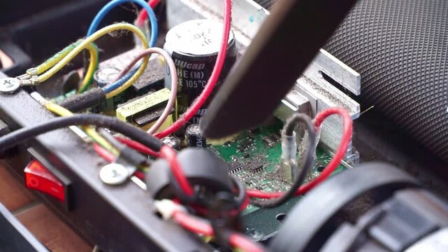 Cleaning dusty internal machine components with vacuum tool, close up shot, electronic repair maintenance, technical service scene.