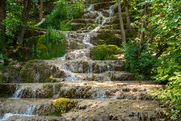Water trickling over natural green mossy tufa rock cascades and travertine terraces at Bigar Waterfall near Kalna village at Stara Planina nature reserve in Serbia. © Dragan