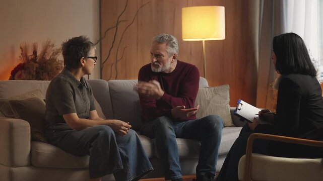 Irritated mature woman argues with husband during psychologist consultation