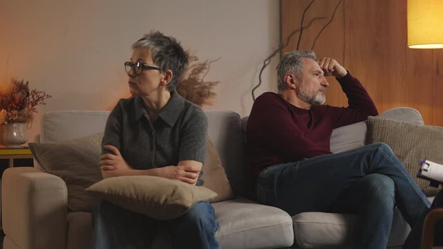 Psychologist talks to upset mature couple sitting apart during therapy session