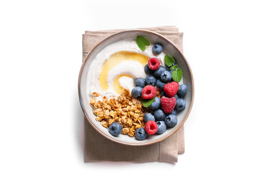 Granola bowl with greek yogurt, berries and honey for healthy breakfast.