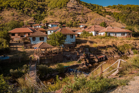 Traditional old houses made of mud, earth, and wood under a steep rocky hill in Topli Do village, showcasing authentic vernacular architecture at Stara Planina in Serbia 13.08.2026
