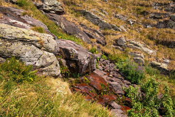 Close up view of fresh water trickling down red sandstone rocks at Razdoljski waterfall (Razdolje) near Kaludjerski Skok at Stara Planina nature reserve, Serbia. © Dragan