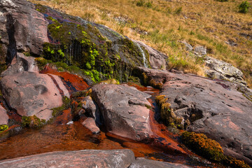 Close up view of fresh water trickling down red sandstone rocks at Razdoljski waterfall (Razdolje) near Kaludjerski Skok at Stara Planina nature reserve, Serbia. © Dragan