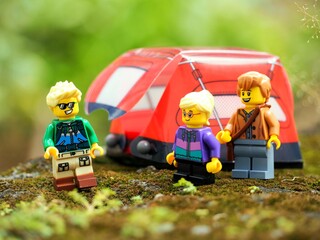 Naklejka premium Indonesia - May 9, 2023 : Mini toy of action figure at grassland with blurred background. Toy photography concept. Camping with tent at outdoor conceptual design. Man and Woman character.