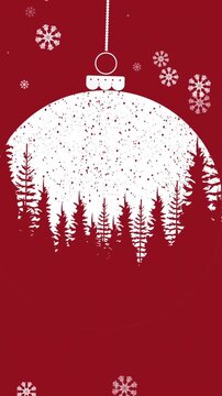 Snowflakes falling over winter landscape on christmas bauble hanging against red background