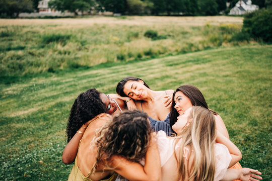 Diverse friends in a tender group hug outdoors