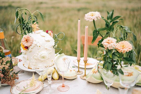 Whimsical outdoor celebration table with decorated cake
