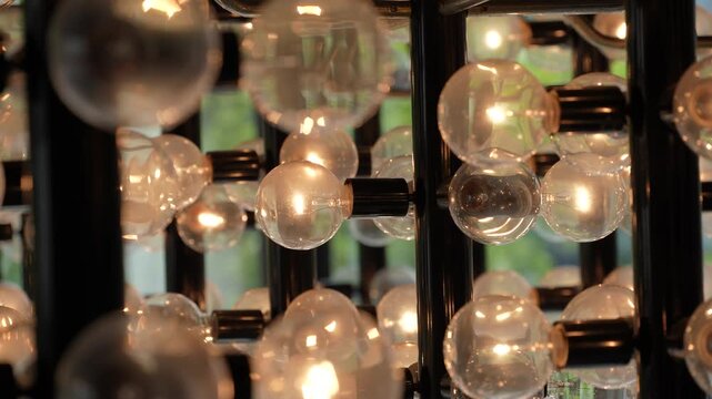 Cinematic close-up of multiple vintage light bulbs glowing with warm light in a modern grid fixture