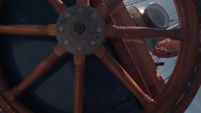 Expeditional sailing vessel moves in the open ocean. Camera spins, rotates and reveals the helm