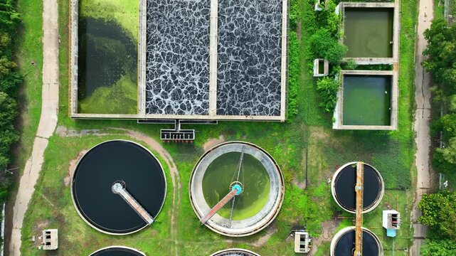 High angle aerial view of industrial wastewater treatment infrastructure with aeration pools and sedimentation systems, representing sustainable water management and responsible industrial operations.