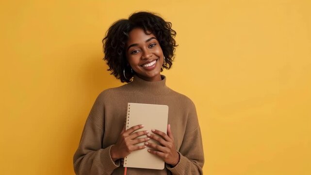 Young Black Woman With Notebook, Joyful Smile, Portrait Against Yellow Background