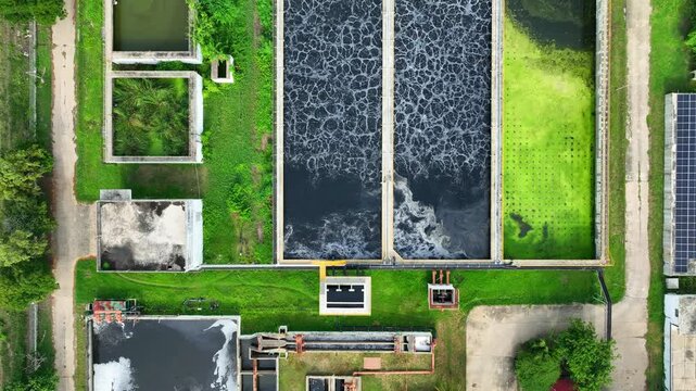 Drone view of a factory wastewater treatment facility with multiple treatment ponds and clarification tanks, highlighting environmental protection, water recycling, and clean technology solutions. 4k.