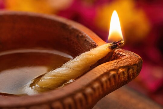 Glowing traditional clay diya with cotton wick for a colorful Diwali celebration