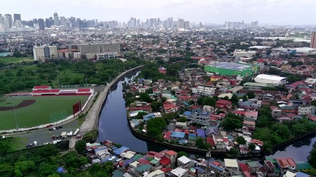 Tracking Shot Wide Establishing Shot of Taguig City in Metro Manila with Landscape of Houses and Buildings with BGC Business Center in the Distance and a River Going Through the City