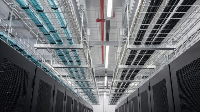Overhead cable trays carrying separated fiber and power routes above server racks, useful commercial concept with generous copy space