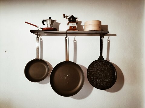 Kitchen wall shelf with hanging pans and coffee tools