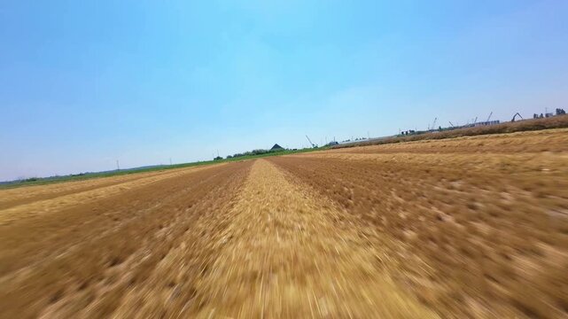 FPV drone fast low flight skim over rural farmland near high voltage power lines and pylons UK