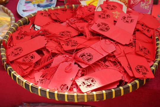 A traditional bamboo basket filled with red lucky tags and tassels featuring the Fu character for Lunar New Year festival decorations.